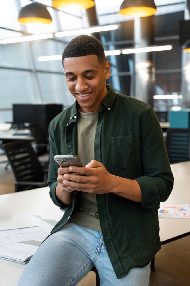 Colaborador sorrindo ao olhar o celular